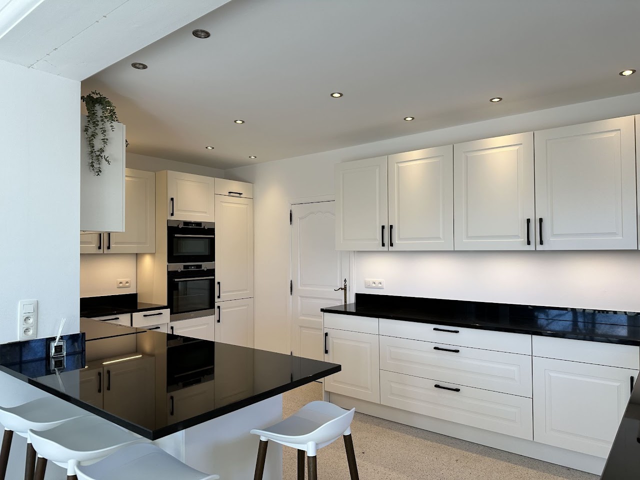 Cuisine avec îlot central et plan de travail noir, villa Domaine de la Chênaie Condroz