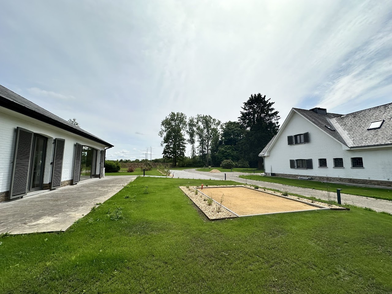 Extérieur du domaine avec jardin arboré et terrain de pétanque, coliving Condroz