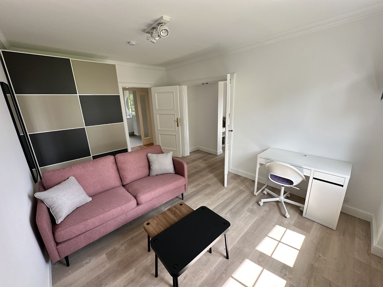 Suite privative avec salon canapé rose et bureau, coliving Domaine de la Chênaie Condroz